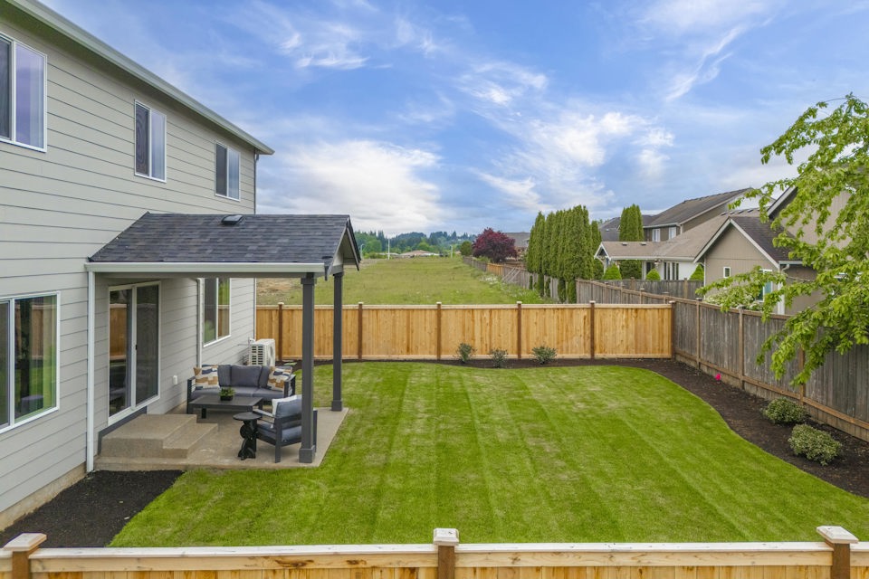 A backyard with a fence and lawn.