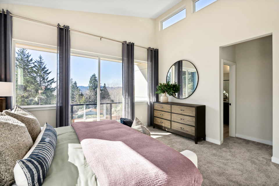 A bedroom with a large window.