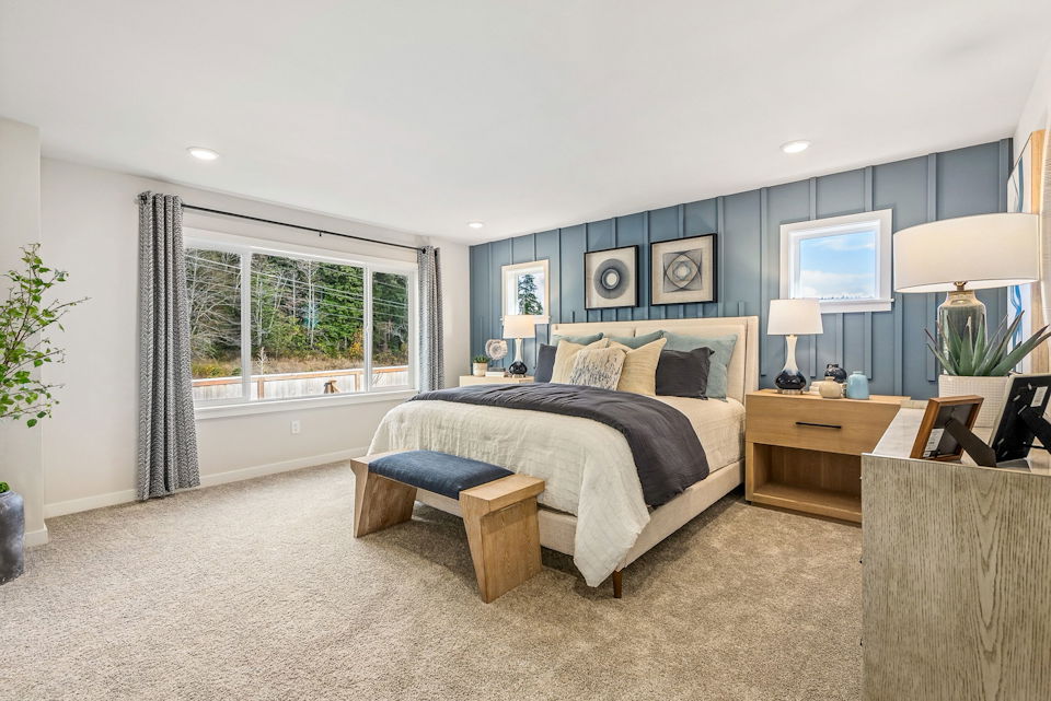 A bedroom with a bed and a bench.