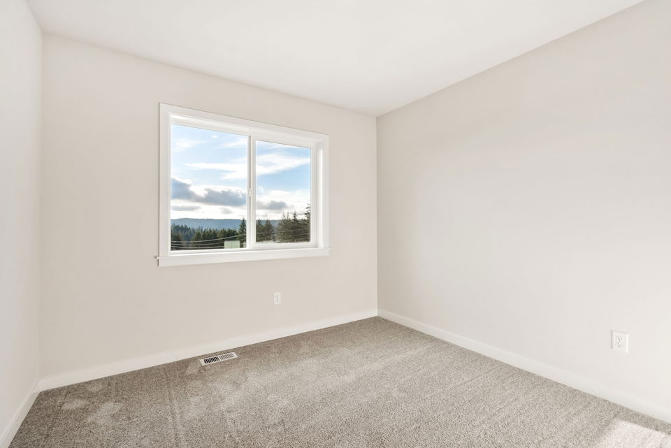 A room with a window and a carpet.