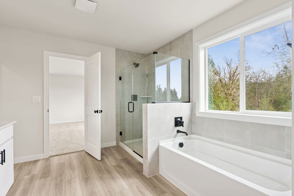 A bathroom with a tub and a window.