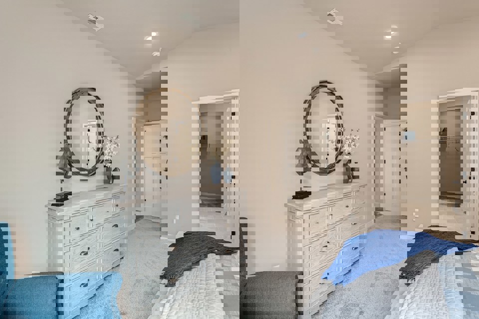 A room with a mirror and a dresser.
