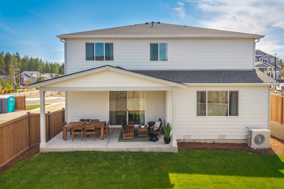 A house with a patio and a table and chairs in the front.