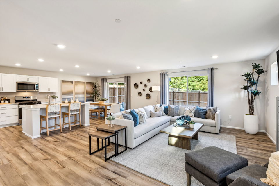 A large living room with a large kitchen and a large window.