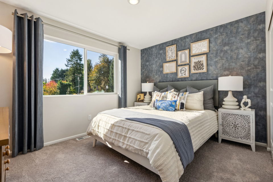 A bedroom with a large window.