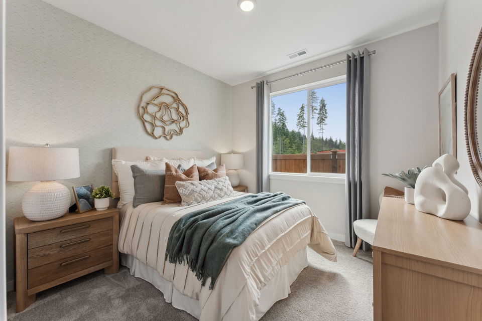 A bedroom with a large window.