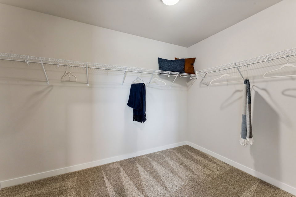 A white bathtub with a towel from the ceiling.