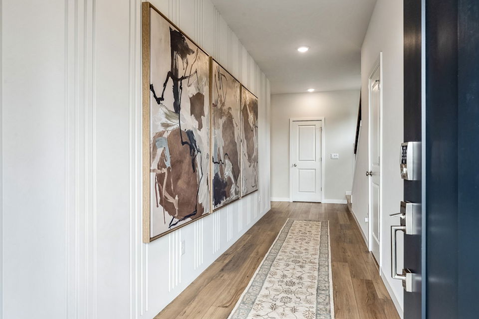 A hallway with a rug and a door.