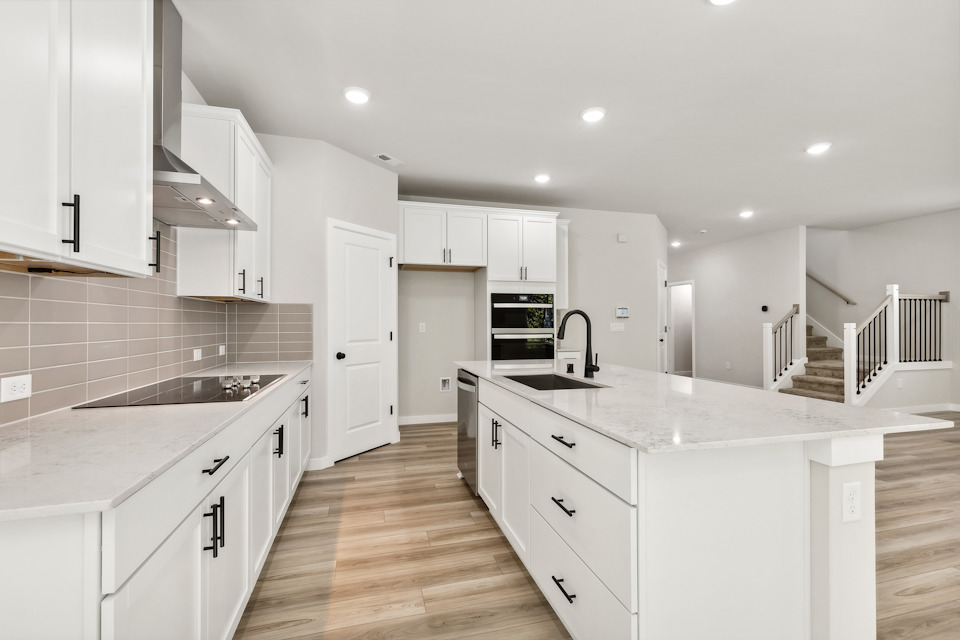 A kitchen with white cabinets.