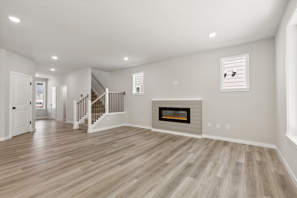 A room with a fireplace and wood floors.