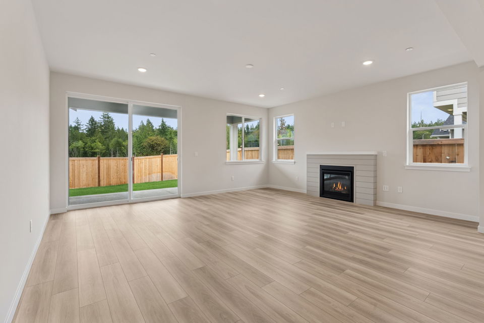 A room with a fireplace and a wood floor.
