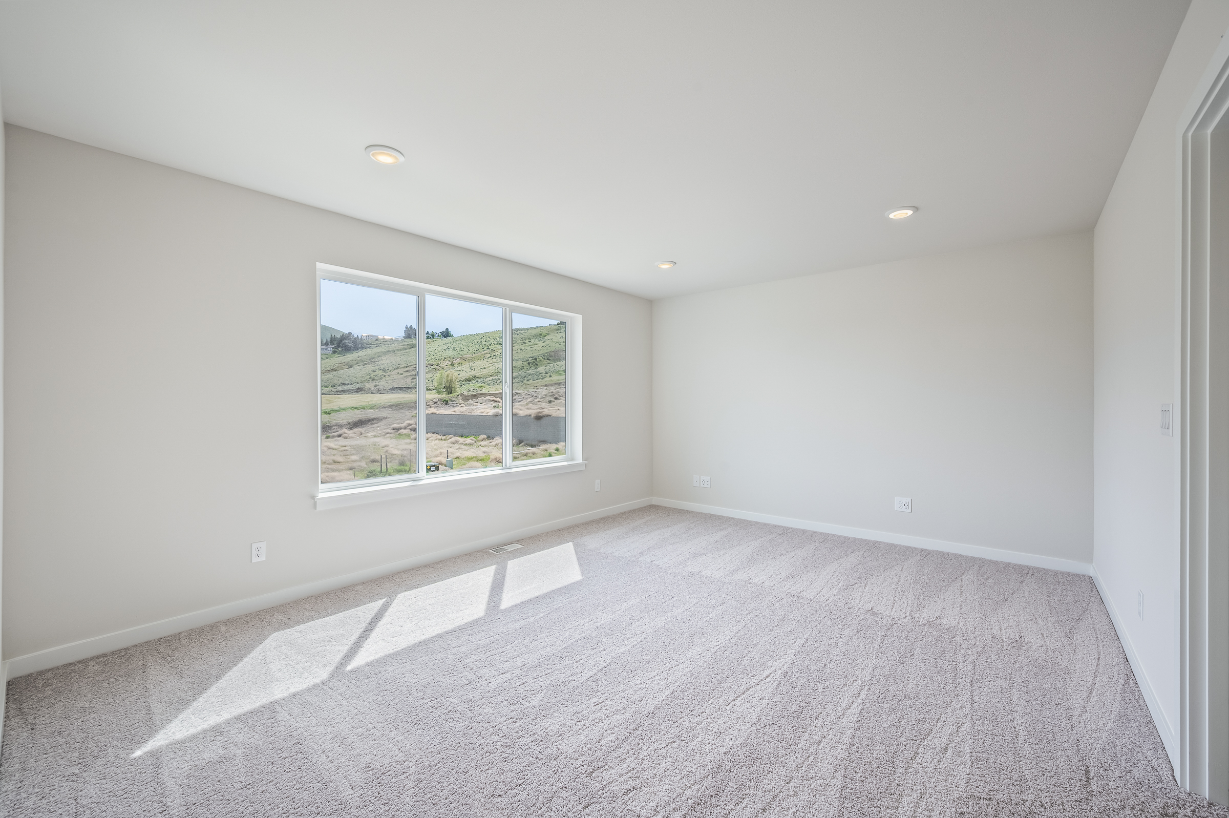 A room with a window and a rug in it.