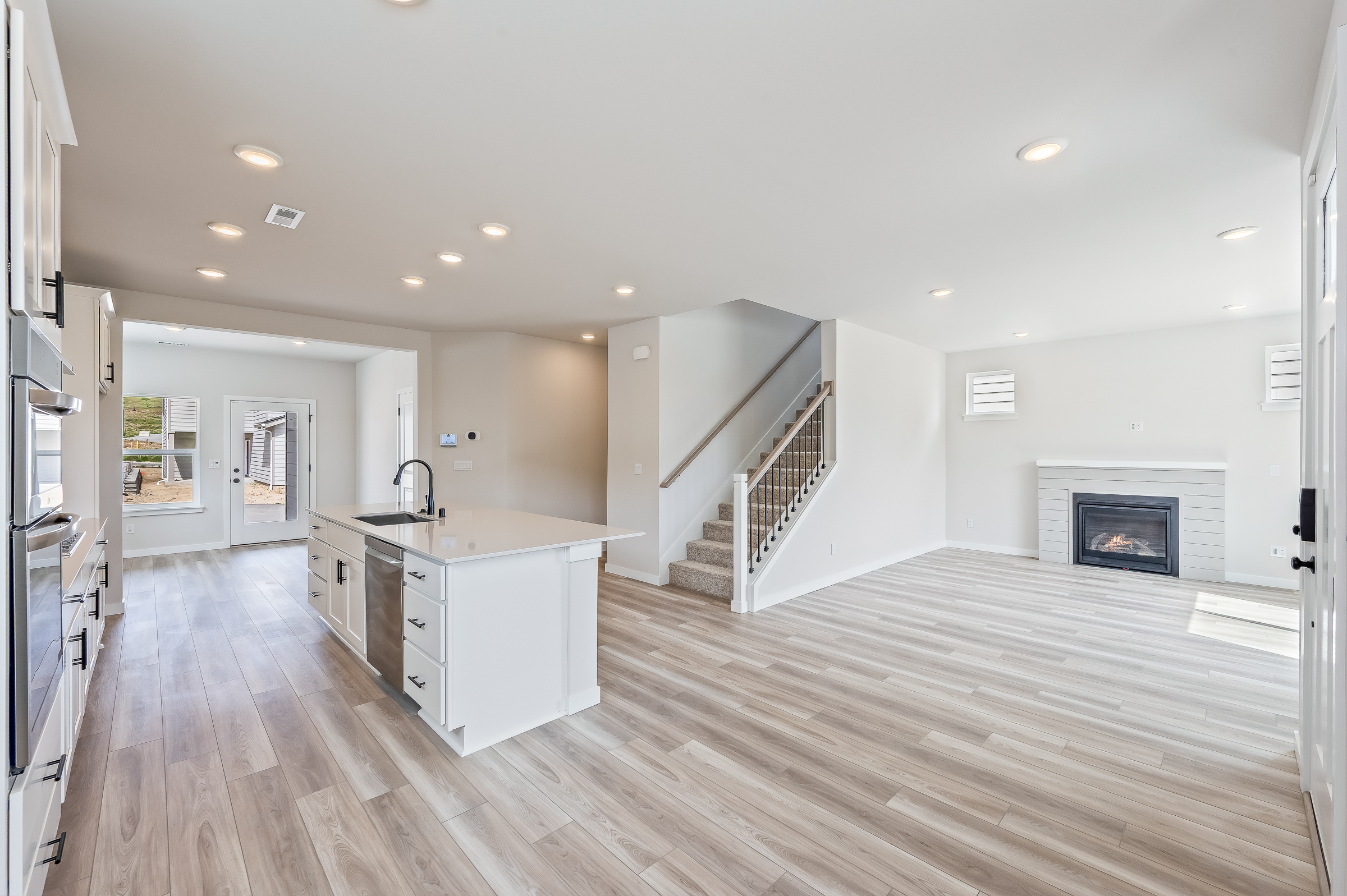 A large kitchen with a wood floor.