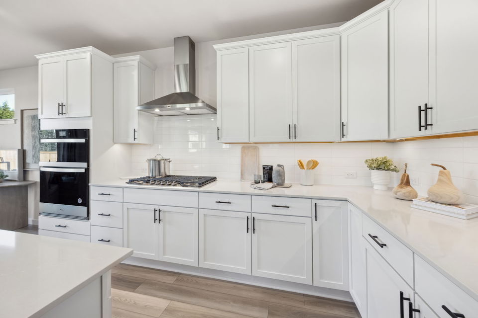 A kitchen with white cabinets.