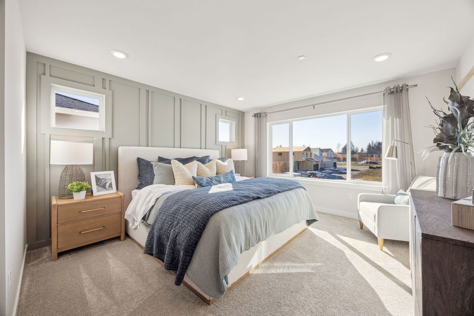 A bedroom with a large window.