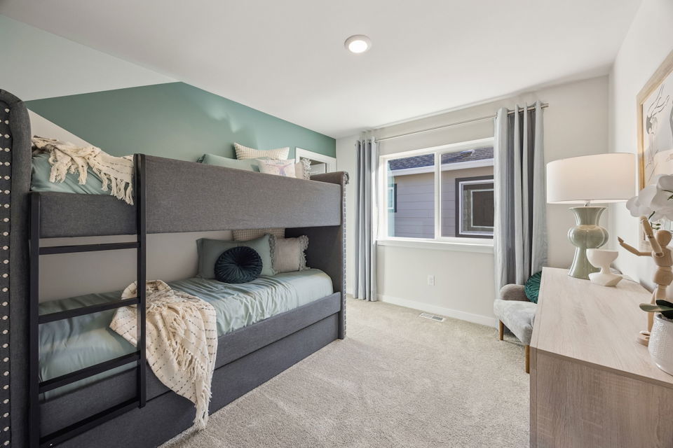 A bedroom with a bed and a desk.