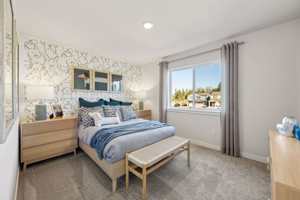 A bedroom with a bed and a bench.