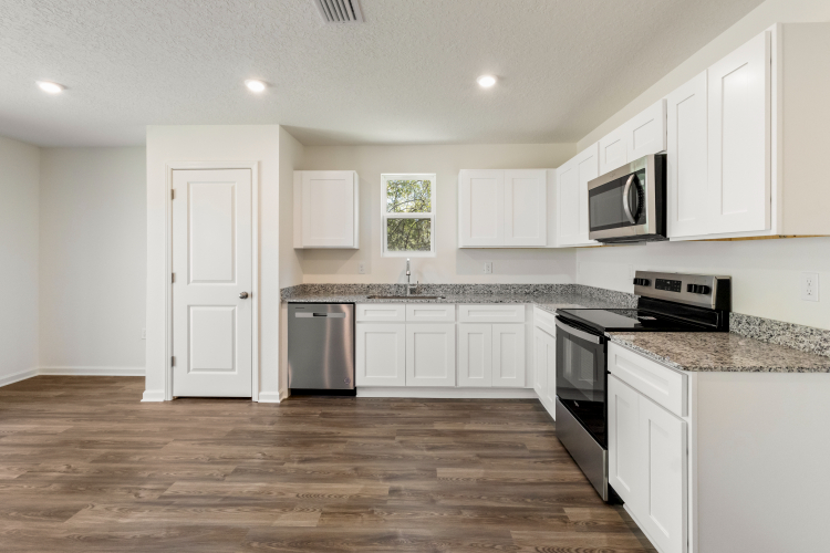 A kitchen with white cabinets.