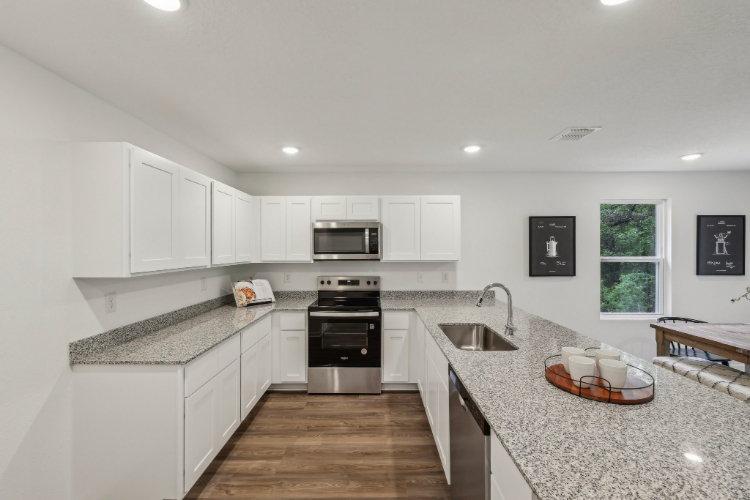 A kitchen with white cabinets.