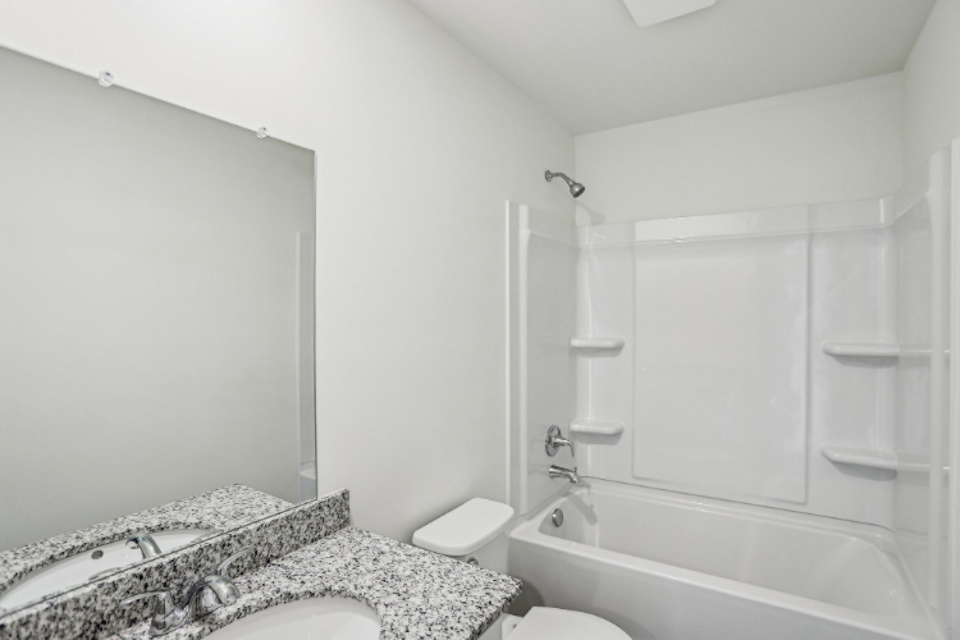 A bathroom with a bathtub sink and toilet.