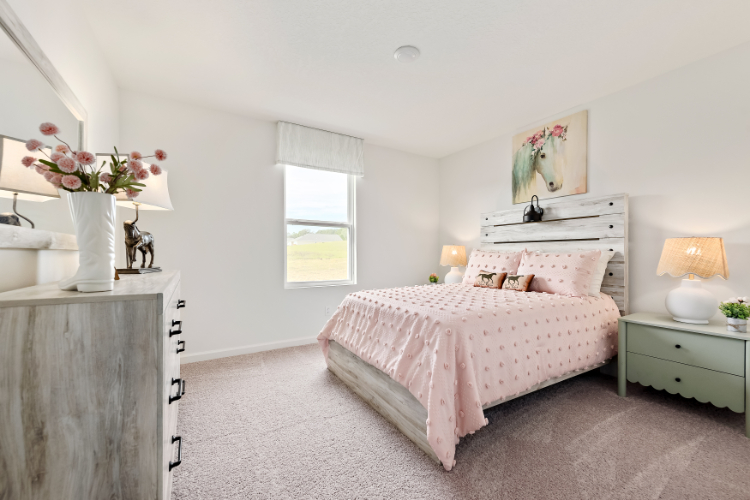 A bedroom with a bed and lamps.