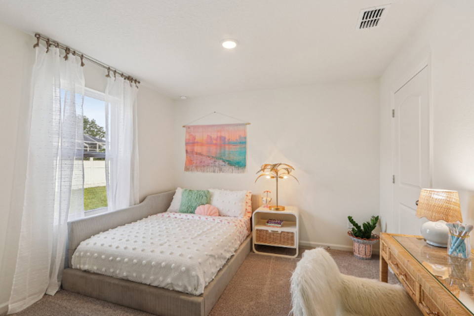 A bedroom with a bed and a table.