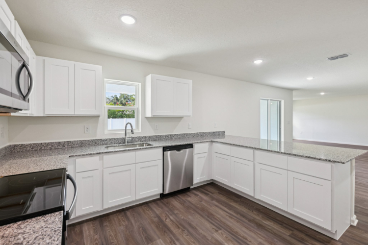 A kitchen with white cabinets.