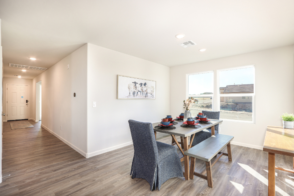 A room with a table chairs and a window.