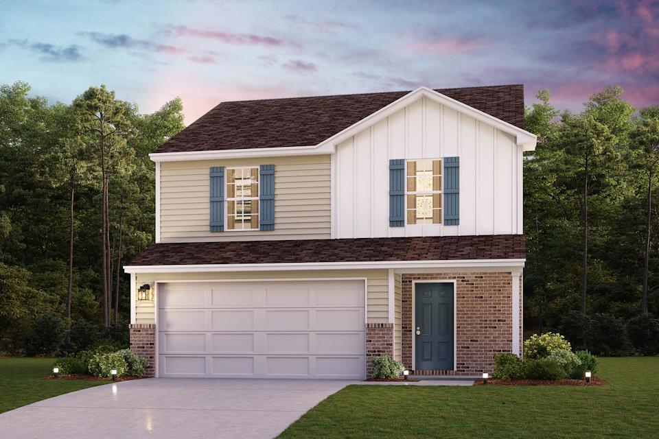 A house with a garage and trees in the back.