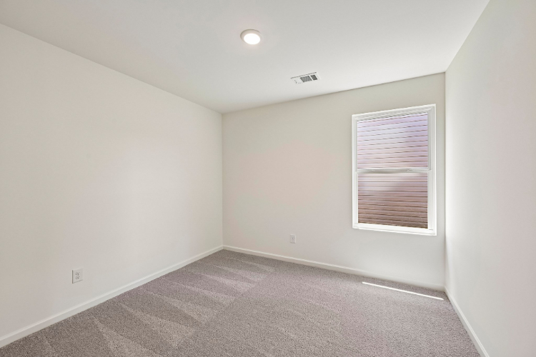 A room with a window and carpet.