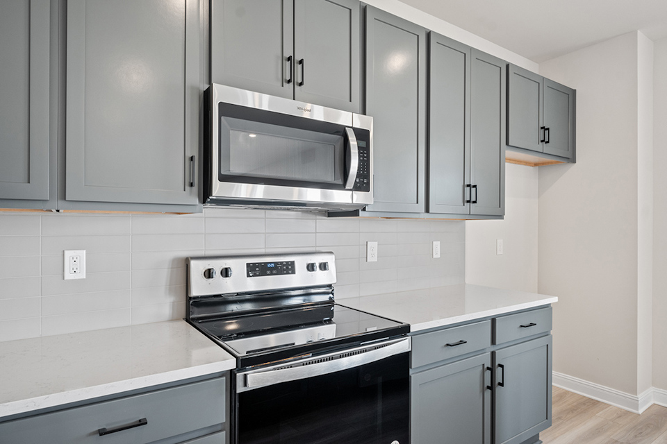 A kitchen with white cabinets.