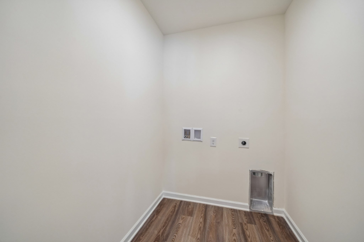 A room with a wood floor and a glass container.