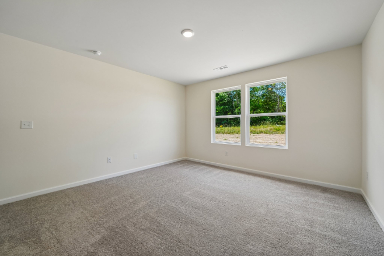A room with a window and a carpet.