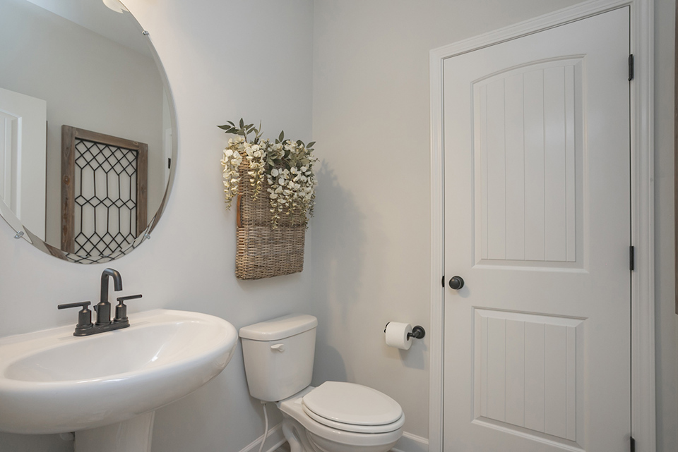 A bathroom with a basket on the toilet.