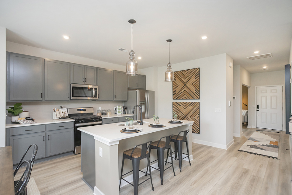 A kitchen with a table and chairs.