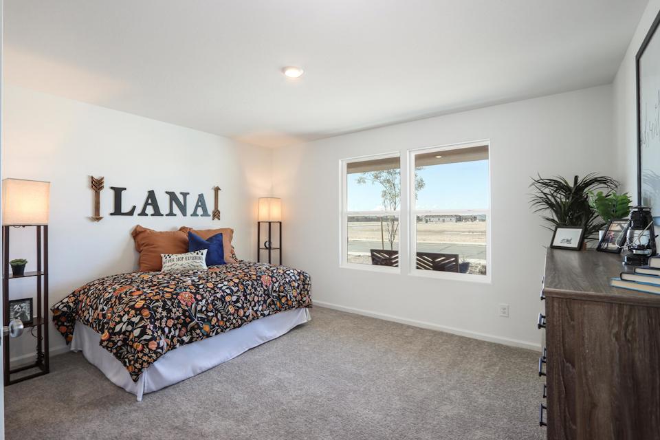 A bedroom with a bed and a desk.