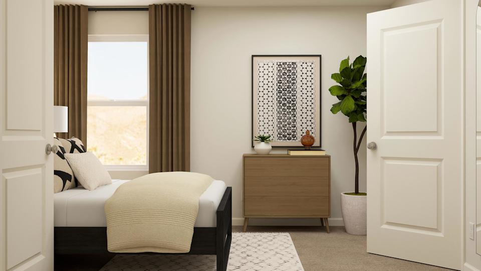 A room with a couch and a table with a plant on it.