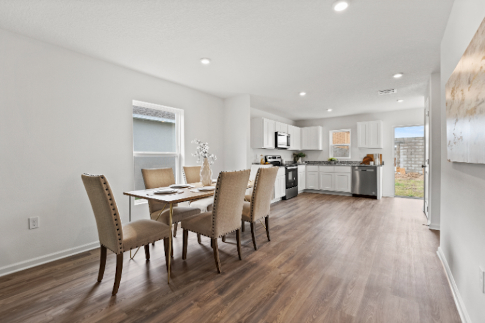A dining room with a wood floor.