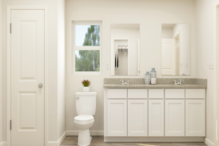 A bathroom with white cabinets.