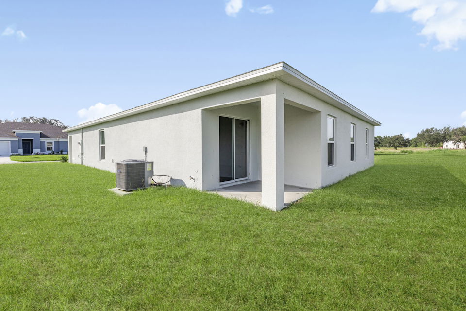 A white house with a grass yard.