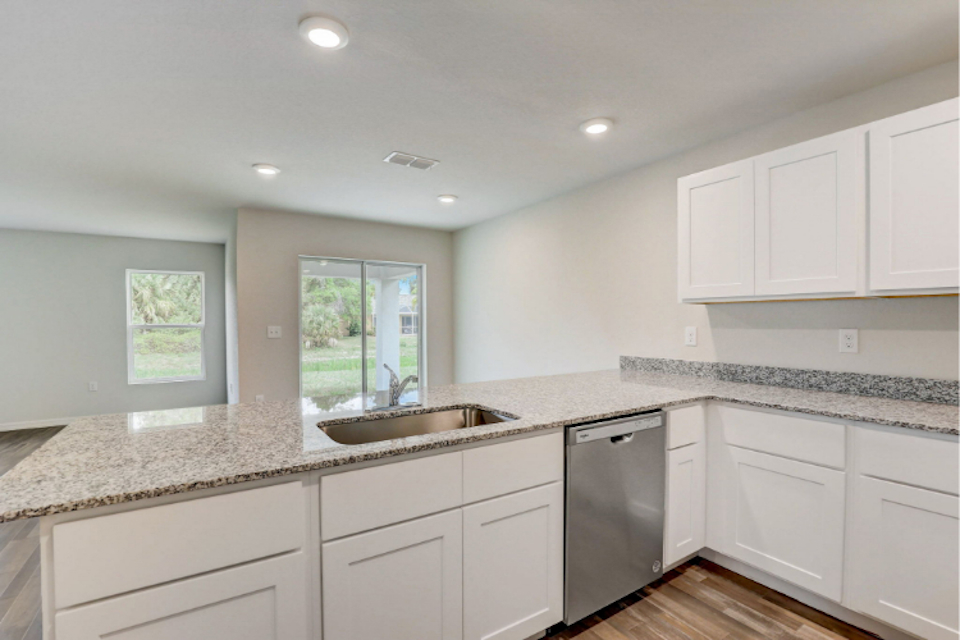 A kitchen with white cabinets.