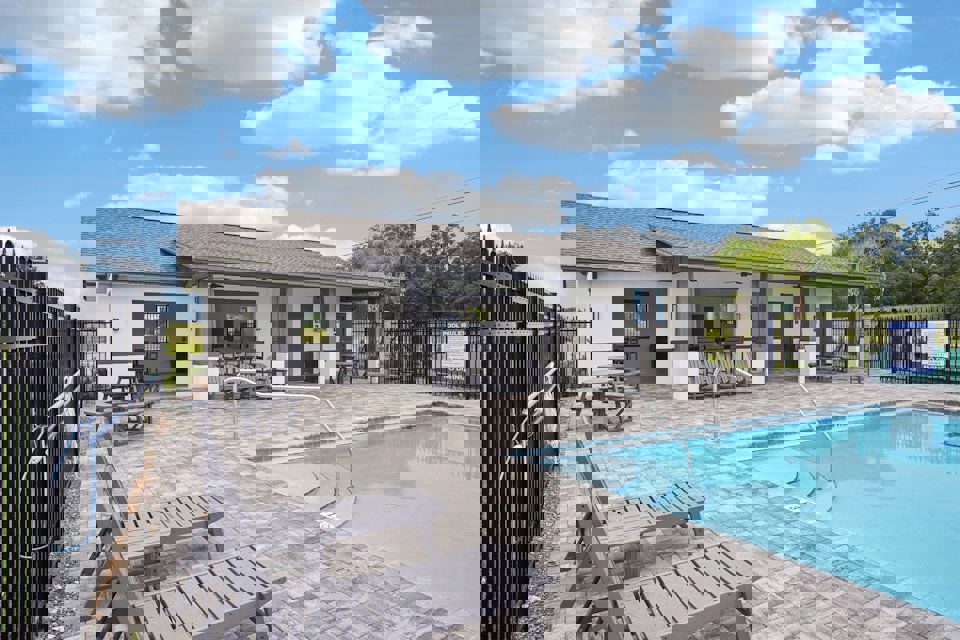 A swimming pool in front of a house.