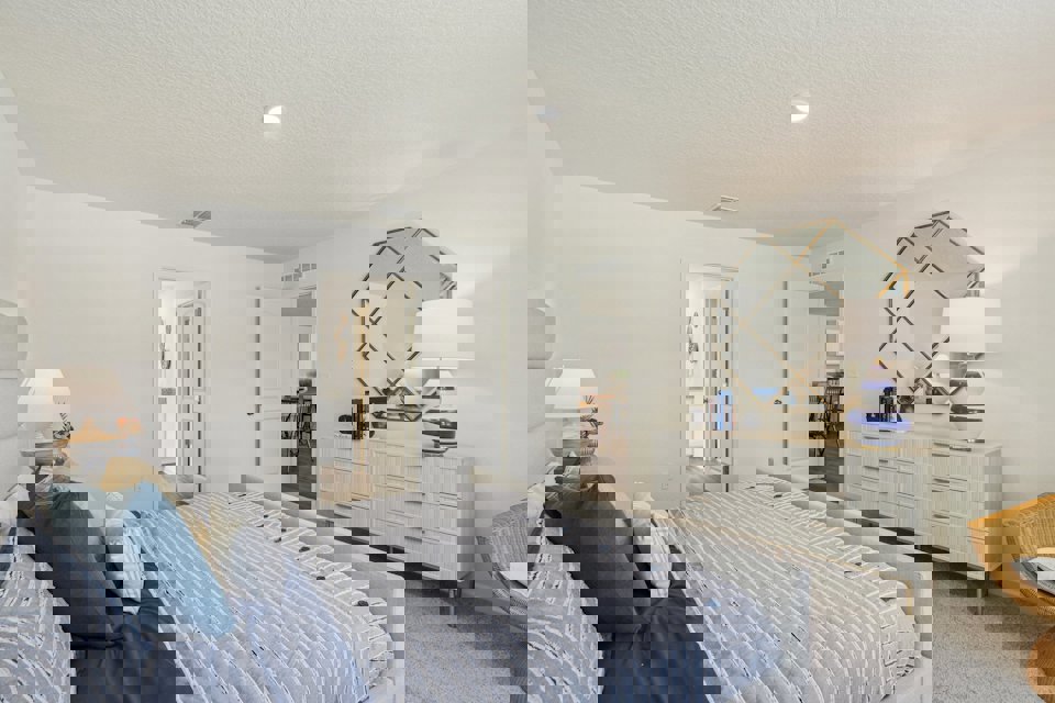 A bedroom with a bed and a mirror.