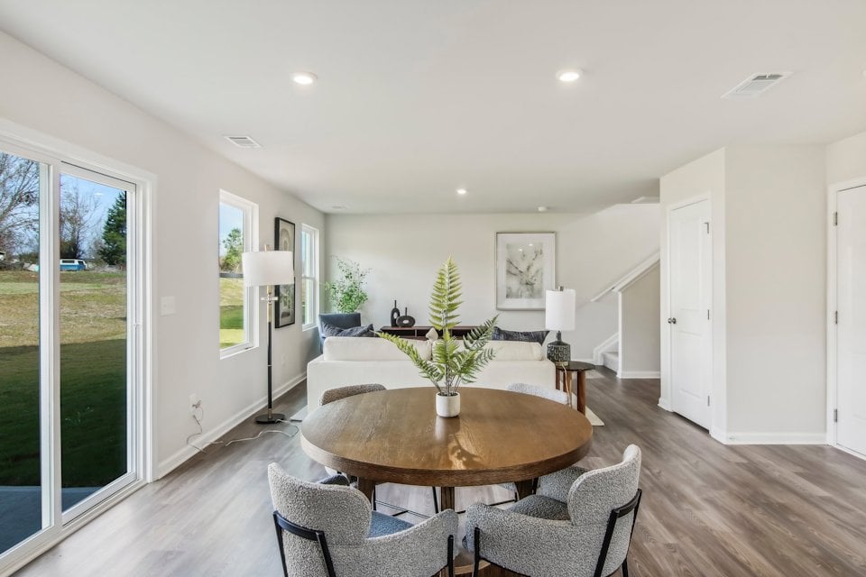 A dining room with a large glass door and a large window.