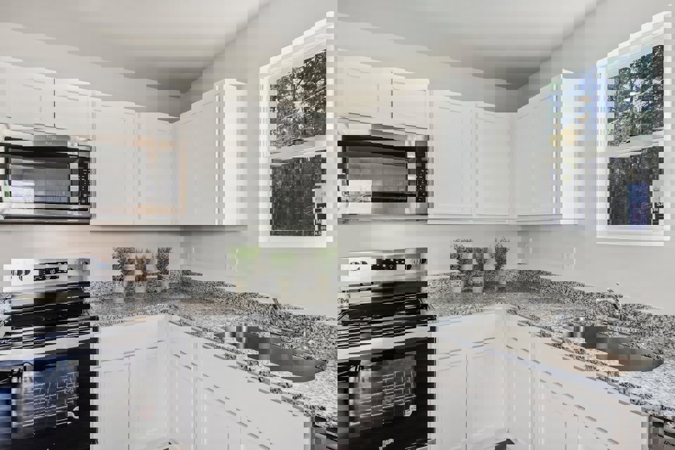 A kitchen with white cabinets.
