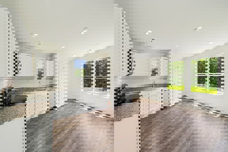 A kitchen with white cabinets.