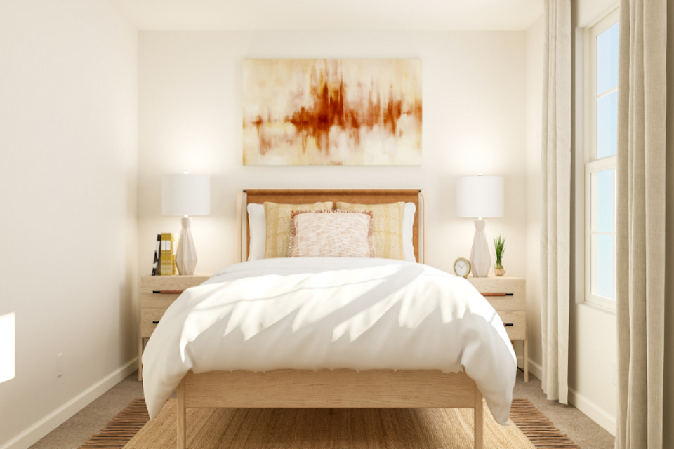 A bed with a painting on the wall.