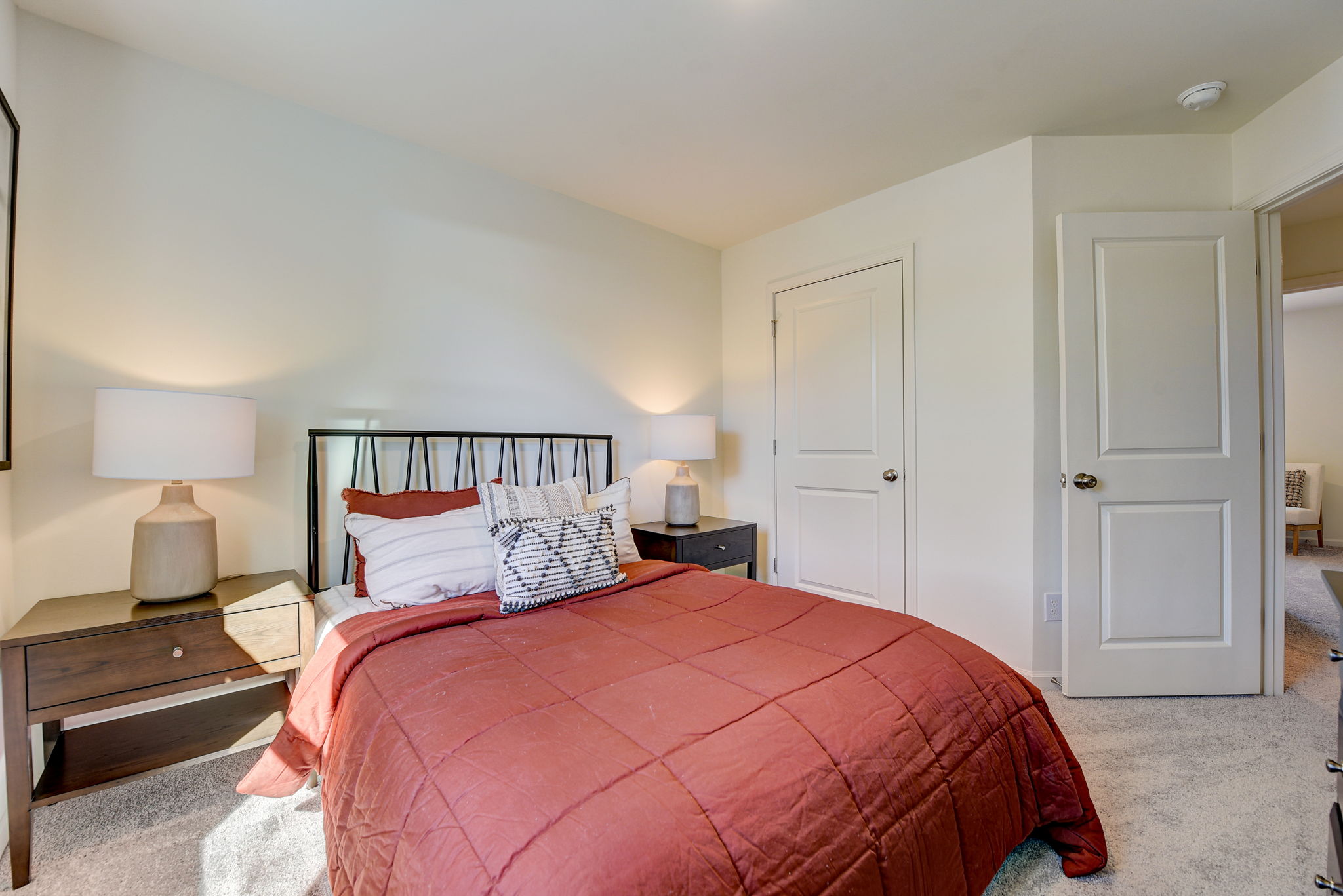 A bedroom with a bed and lamps.